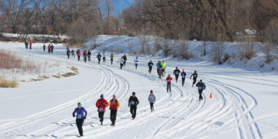 people running on a frozen, snow covered river during the Rio Frio Ice Fest Alamosa CO 5K