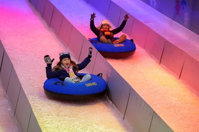 2 kids go snow tubing indoors at Gaylord Rockies in Aurora, Colorado