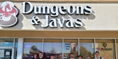 Group of people stand out front under the sign for Dungeons & Javas in Colorado Springs