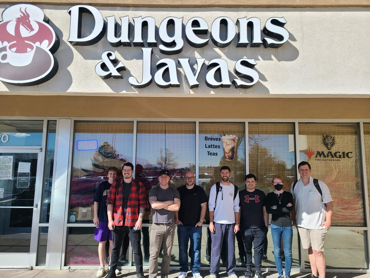 Group of people stand out front under the sign for Dungeons & Javas in Colorado Springs