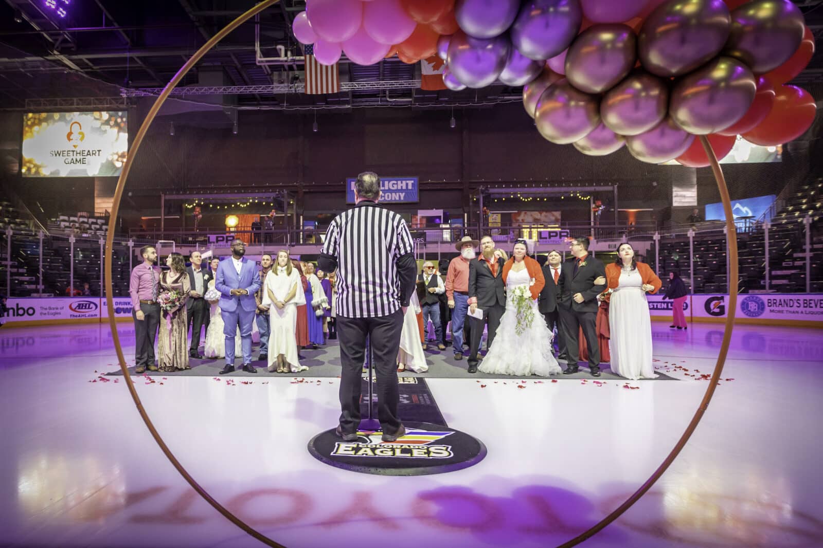 view of ref and couples lined up at on the iuce rink at fLoveland Valentine's Day Group Wedding