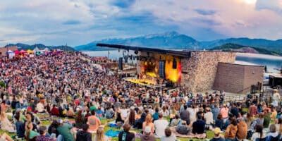 panorama of a packed crowd at the Dillon Amphitheater with views of the mountains and lake to the west