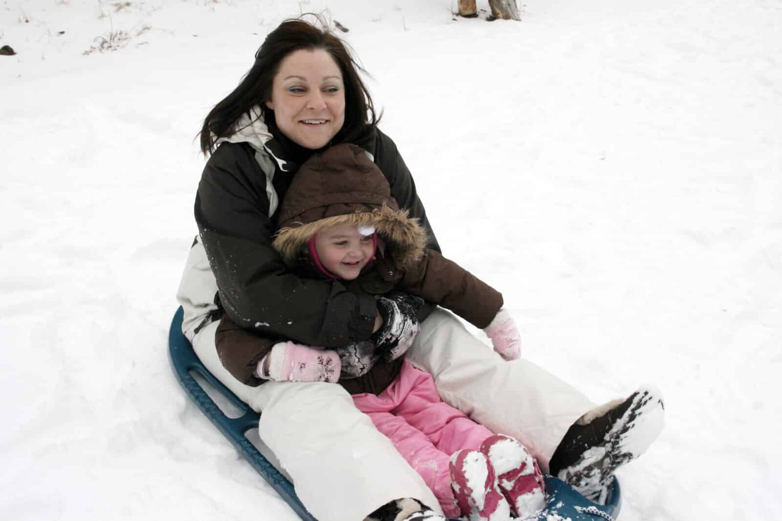 Woman and girl sledding at Hidden Valley in Rocky Mountain National Park