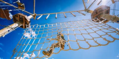 looking up at someone crossing the rope ladder at the Open Air Adventure Park in Estes Park
