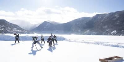 adults play ice hockey on Grand Lake in Colorado