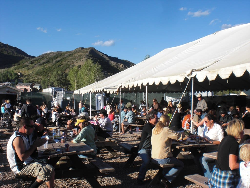 people eating outside on picnic tables at the Snowmass Rodeo