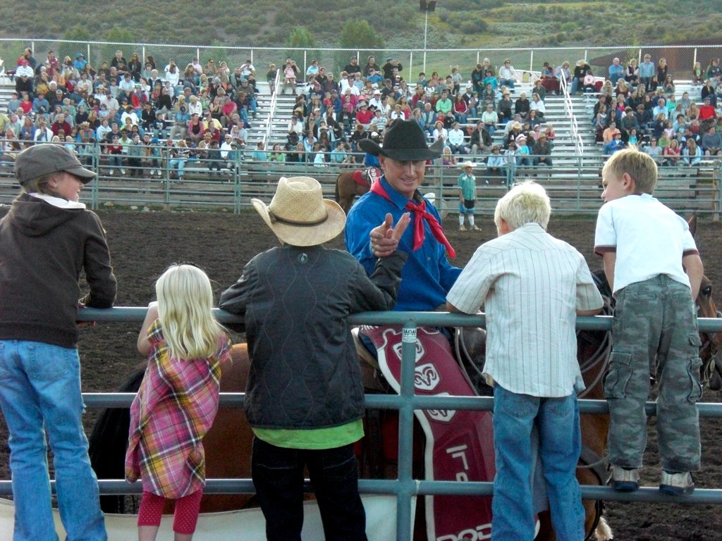 Kids stand along the fence watching the Snowmass Rodeo